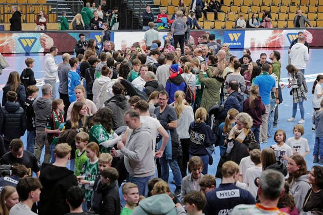 11 02 2026, xovx, Handball Daikin Handball Bundesliga, HSG Wetzlar Füchse Berlin Mathias Gidsel Superstar Füchse Berlin Well over 30 minutes after the end of the game, Nils Lichtlein Füchse Berlin stands patiently in the crowd surrounded by many young and old fans and diligently signs autographs Wetzlar Buderus Arena Hessen Germany EN