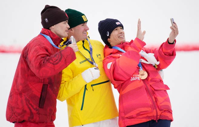 Gold medalist Cooper Woods of Australia (C), silver medalist Mikael Kingsbury of Canada (L) and bronze medalist Ikuma Horishima of Japan pose for a selfie after the Men s Freestyle Skiing Moguls competition at the Milano Cortina 2026 Winter Olympic Games, Olympische Spiele, Olympia, OS in Livigno, Italy, on Thursday, February 12, 2026.  OLY20260212801 BOBxSTRONG