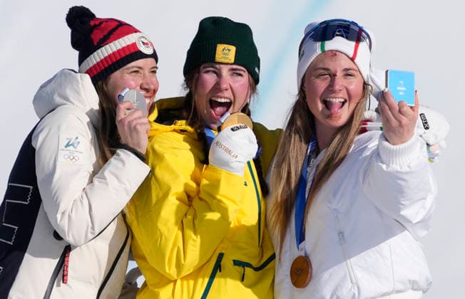 Gold medalist Josie Baff of Australia (C), silver medalist Eva Adamczykova of Czechia (L) and bronze medalist Michela Moioli of Italy take a selfie on the podium after the Women s Snowboard Cross finals at the Milano Cortina 2026 Winter Olympic Games, Olympische Spiele, Olympia, OS in Livigno, Italy, on Friday, February 13, 2026.  OLY20260213805 BOBxSTRONG