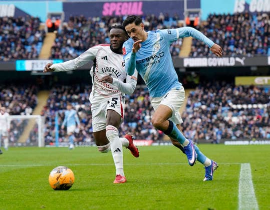 Manchester, England, 14th February 2026. Michael Rose of Salford City and Tijjani Reijnders of Manchester City during the Manchester City vs Salford City FA Cup fourth round match at the Etihad Stadium, Manchester. Picture credit should read: Andrew Yates Sportimage EDITORIAL USE ONLY. No use with unauthorised audio, video, data, fixture lists, club league logos or live services. Online in-match use limited to 120 images, no video emulation. No use in betting, games or single club league player publications. SPI_036_AY_Man_City_Salford SPI-4533-0038