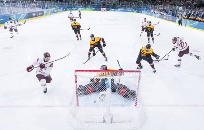 (260214) -- MILAN, Feb. 14, 2026 -- Dans Locmelis (2nd L) of Latvia shoots to score during the Ice hockey, Eishockey men s preliminary round group C match between Germany and Latvia of the Milan-Cortina 2026 Olympic Winter games, Winterspiele,Spiele, Summer games in Milan, Italy, Feb. 14, 2026. ) (MICO2026)ITALY-MILAN-OLYMPIC WINTER GAMES-ICE HOCKEY-MEN-PRELIMINARY-GER VS LAT SunxFei 