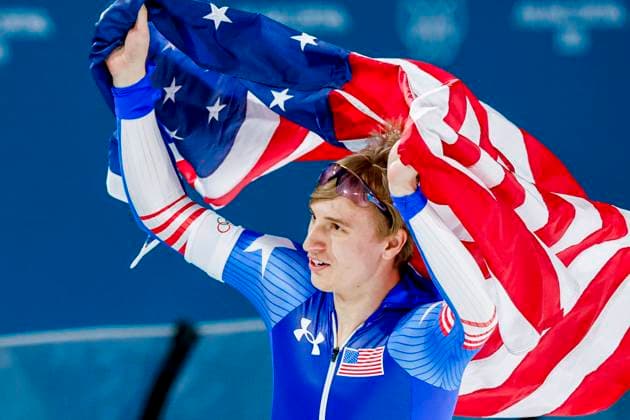 Jordan Stolz of United States of America celebrating and holding flag after Men s 500m, Milano Cortina 2026 Winter Olympics: Day 8, Speed skating, Eisschnelllauf - Milano Cortina 2026 Winter Olympics: Day 8, Milano Speed Skating Stadium, February 14, 2026, Milan, Italy.