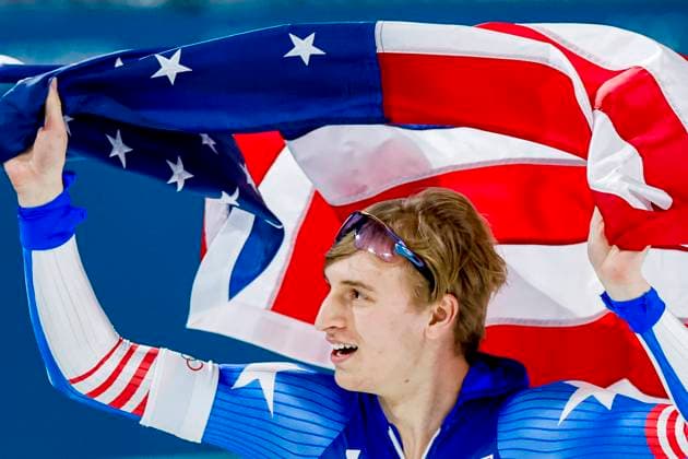 Jordan Stolz of United States of America celebrating and holding flag after Men s 500m, Milano Cortina 2026 Winter Olympics: Day 8, Speed skating, Eisschnelllauf - Milano Cortina 2026 Winter Olympics: Day 8, Milano Speed Skating Stadium, February 14, 2026, Milan, Italy.