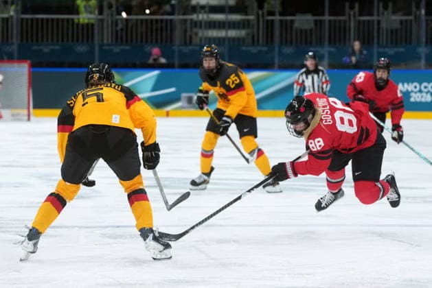 February 14, 2026, Milan, ITALY: Canada s Julia Gosling (88) falls in front of Germany s Charlott Schaffrath (5) during the second period of a women s hockey quarterfinal game at the 2026 Winter Olympics, in Milan, Saturday, Feb. 14, 2026. Canada News - February 14, 2026  - ZUMAc35_ 20260214_zaf_c35_033 Copyright: xDarrylxDyckx