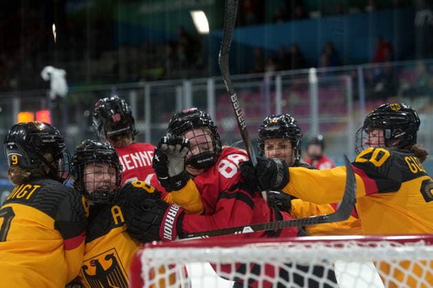 February 14, 2026, Milan, ITALY: Canada s Julia Gosling (88) gets checked by Germany s Daria Gleissner (20) and teammate Ronja Hark (8) during the third period of a women s hockey quarterfinal game at the 2026 Winter Olympics, in Milan, Saturday, Feb. 14, 2026. Canada News - February 14, 2026  - ZUMAc35_ 20260214_zaf_c35_069 Copyright: xDarrylxDyckx