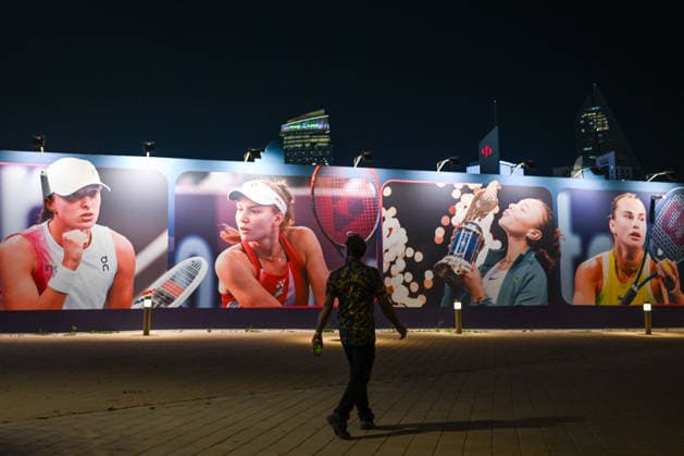 Doha Racket Exchange: WTA, Tennis Damen 1000 Finale Gives Way To ATP, Tennis Herren 500 Arrivals DOHA, QATAR FEBRUARY 14: A silhouette of a spectator walking past a large-scale mural featuring WTA stars Iga Swiatek, Elena Rybakina, Amanda Anisimova and Aryna Sabalenka during the final night of the 2026 Qatar TotalEnergies Open at the Khalifa International Tennis and Squash Complex in Doha, Qatar, February 14, 2026. The evening marks a major logistical transition at the venue as the WTA 1000 event concludes and the site prepares for the arrival of the ATP 500 tour with early practice sessions and media preparations already underway. Doha Qatar  Copyright: xArturxWidakx originalFilename:widak-doharack260214_npfCe.jpg