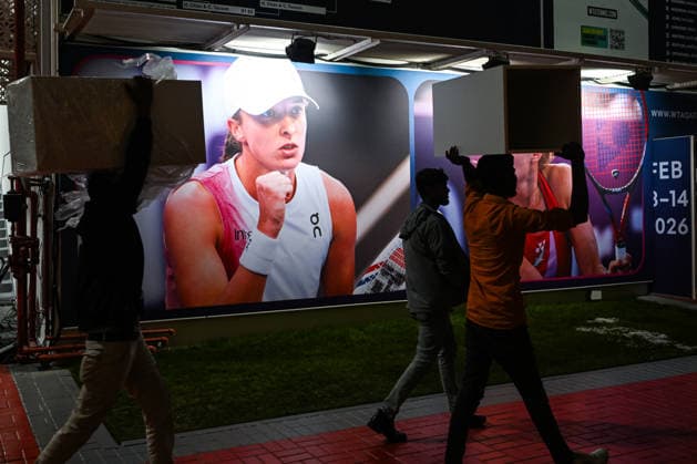Doha Racket Exchange: WTA, Tennis Damen 1000 Finale Gives Way To ATP, Tennis Herren 500 Arrivals DOHA, QATAR FEBRUARY 14: Workers carry equipment past tournament branding and player murals featuring Iga ÅöwiÄÖtek during the final night of the Qatar TotalEnergies Open at the Khalifa International Tennis and Squash Complex in Doha, Qatar, February 14, 2026. The evening marks a major logistical transition at the venue as the WTA 1000 event concludes and the site prepares for the arrival of the ATP 500 Qatar ExxonMobil Open tour with early practice sessions and media preparations Doha Qatar  Copyright: xArturxWidakx originalFilename:widak-doharack260214_npom5.jpg