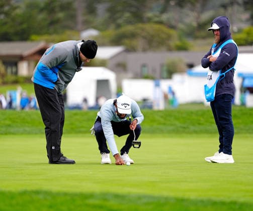PEBBLE BEACH, CA - FEBRUARY 14: PGA, Golf Herren golfer Akshay Bhatia gets a ruling from a rules official as his ball was moving from the wind on the 18th green on February 14, 2026, during the third round of the PGA AT&T Pebble Beach Pro-Am at the Pebble Beach Golf Links at Pebble Beach, California. (Photo by Brian Spurlock Icon Sportswire) GOLF: FEB 14 PGA AT&T Pebble Beach Pro-Am EDITORIAL USE ONLY Icon26021447