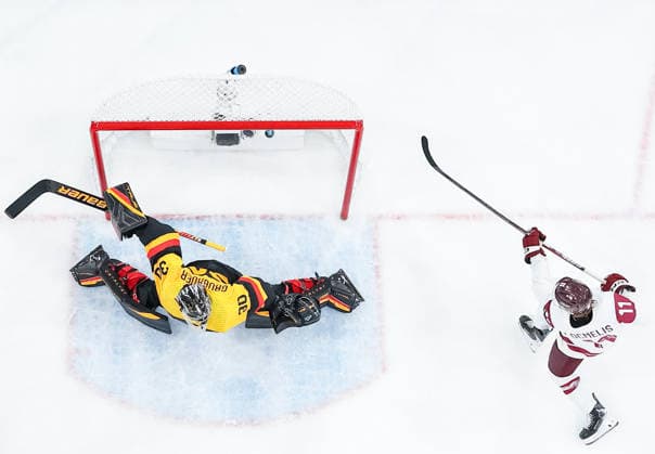 (260215) -- MILAN, Feb. 15, 2026 -- Dans Locmelis (R) of Latvia scores during the Ice hockey, Eishockey men s preliminary round group C match between Germany and Latvia of the Milan-Cortina 2026 Olympic Winter games, Winterspiele,Spiele, Summer games in Milan, Italy, Feb. 14, 2026. ) (MICO2026)ITALY-MILAN-OLYMPIC WINTER GAMES-ICE HOCKEY-MEN-PRELIMINARY-GER VS LAT SunxFei 
