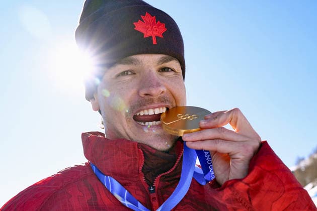 Milan Cortina Olympics: Freestyle skiing Canadian freestyle skier Mikael Kingsbury bites his gold medal after winning the men s dual moguls at the Milan Cortina Olympics on Feb. 15, 2026, at Livigno Aerials &amp; Moguls Park in Livigno, Italy.  A14AA0005288253P