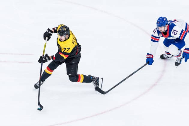 MILANO, ITALY - FEBRUARY 15: John Peterka (Germany, 77) controls the puck against Dylan Larkin (United States of America, 21) during the Ice hockey, Eishockey Men United States of America vs Germany - Preliminary Round - Group C at the Milano Cortina 2026 Olympics at Milano Santagiulia Ice Hockey Arena on day 9 of the Milano Cortina 2026 Olympics on February 15, 2026 in Milano, Italy. Editorial use only. Italy Copyright: xSteffiexWunderlx