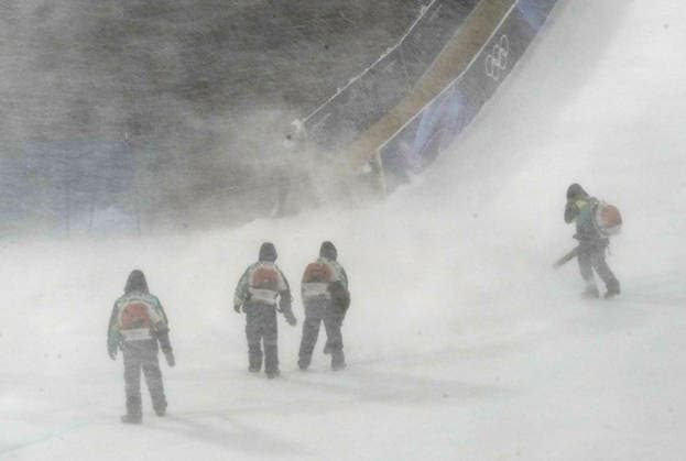 Course workers try to blow snow from the jump during a heavy snowstorm before the start of the Women s Freeski Big Air Final at the Milano Cortina 2026 Winter Olympic Games, Olympische Spiele, Olympia, OS in Livigno, Italy, on Monday, February 16, 2026.  OLY20260216820c BOBxSTRONG