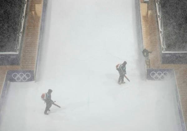 Course workers try to blow snow from the jump during a heavy snowstorm before the start of the Women s Freeski Big Air Final at the Milano Cortina 2026 Winter Olympic Games, Olympische Spiele, Olympia, OS in Livigno, Italy, on Monday, February 16, 2026.  OLY20260216825 BOBxSTRONG