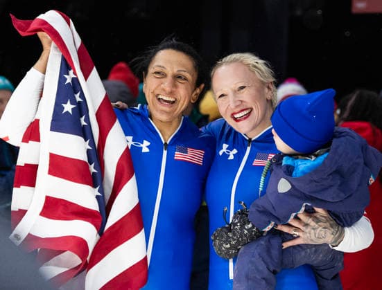 February 16, 2026, Cortina D ampezzo, Lombardy, Italy: Golf medal winner Elana Meyers Taylor of the USA, left, with teammate and bronze medal winner Kaillie Armbruster Humphries after the Women s Monobob at the Cortina Sliding Centre for the Milano Cortina 2026 Winter Olympics. Armbruster Humphries is holding her son Aulden. Cortina D ampezzo Italy - ZUMAsc5_ 20260216_oly_sc5_004 Copyright: xErichxSchlegelx
