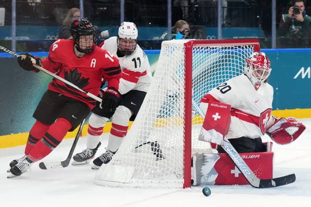 February 16, 2026, Milan, ITALY: Canada s Renata Fast (14) and Switzerland s Laura Zimmermann (11) follow the puck around back of Switzerland s Andrea Braendli (20) as she guards the net during first period women s Olympic semifinal hockey action at the 2026 Milan Cortina Winter Olympics in Milan, Monday, Feb. 16, 2026. Canada News - February 16, 2026  - ZUMAc35_ 20260216_zaf_c35_182 Copyright: xNathanxDenettex