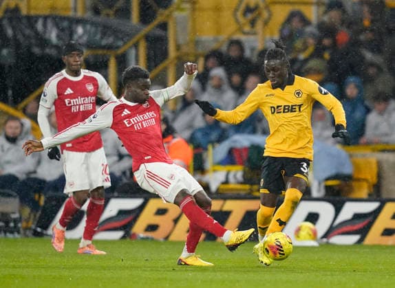 Wolverhampton, England, 18th February 2026. Bukayo Saka of Arsenal tackles Mateus Mane of Wolverhampton Wanderers during the Wolverhampton Wanderers vs Arsenal Premier League match at Molineux, Wolverhampton. Picture credit should read: Andrew Yates Sportimage EDITORIAL USE ONLY. No use with unauthorised audio, video, data, fixture lists, club league logos or live services. Online in-match use limited to 120 images, no video emulation. No use in betting, games or single club league player publications. SPI_025_AY_Wolves_Arsenal SPI-4539-0027