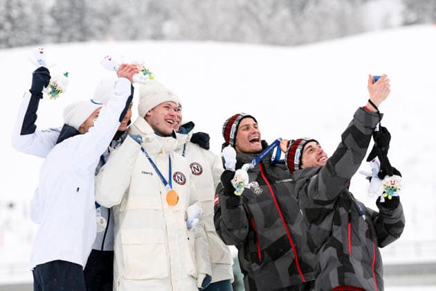 OLYMPICS - Winter Olympic Games, Olympische Spiele, Olympia, OS Milano Cortina 2026 TESERO,ITALY,19.FEB.26 - OLYMPICS, NORDIC SKIING, NORDIC COMBINED - Winter Olympic Games Milano Cortina 2026, team sprint, medal ceremony. Image shows the rejoicing of Ilkka Herola and Eero Hirvonen (FIN), Andreas Skoglund and Jens Luraas Oftebro (NOR), Stefan Rettenegger and Johannes Lamparter (AUT). Keywords: medal, mascot.  GEPAxpictures xMatthiasxTrinkl