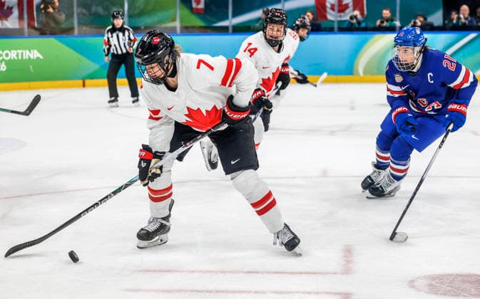 Canada s Laura Stacey (7) moves the puck in front of Canada s Renata Fast (14) and United States Hilary Knight (21) in the second period of the Women s Hockey Gold Medal Game between Canada and the USA at the Milano Santagiulia Ice hockey, Eishockey Arena in Milan, Italy, on Thursday, February 19, 2026.  OLY20260219321 AARONxJOSEFCZYK