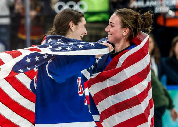 Team USA members celebrate after United States Megan Keller (5) scored the winning goal in sudden death three on three overtime of the Gold Medal Game between Canada and the USA at the Milano Santagiulia Ice hockey, Eishockey Arena in Milan, Italy, on Thursday, February 19, 2026. The USA won the game 2-1 to win the gold medal. Canada wins the Silver and Switzerland won the Bronze medal.  OLY20260219337 AARONxJOSEFCZYK