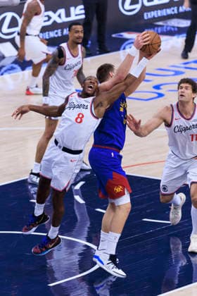 February 19, 2026, Inglewood, California, USA: Nikola Jokic 15 of the Denver Nuggets and Kris Dunn 8 of the Los Angeles Clippers reach for the rebound during their regular season NBA, Basketball Herren, USA game on Thursday February 19, 2026 at Intuit Dome in Inglewood, California. ARIANA RUIZ PI Clippers Vs. Nuggets  - ZUMAp124 20260219_zaa_p124_011 Copyright: xArianaxRuizx