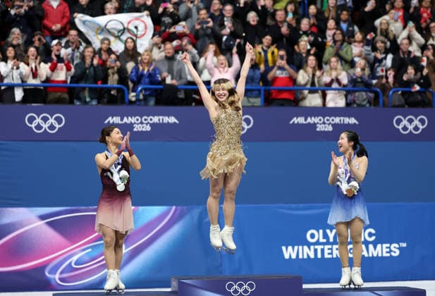 (260220) -- MILAN, Feb. 20, 2026 -- Gold medalist Alysa Liu (C) of the United States jumps on the podium during the awarding ceremony of the Figure skating, Eiskunstlauf women single skating event at the Milan-Cortina 2026 Olympic Winter games, Winterspiele,Spiele, Summer games in Milan, Italy, Feb. 19, 2026. ) (MICO2026)ITALY-MILAN-OLYMPIC WINTER GAMES-FIGURE SKATING-WOMEN SINGLE SKATING-FREE SKATING LixMing 