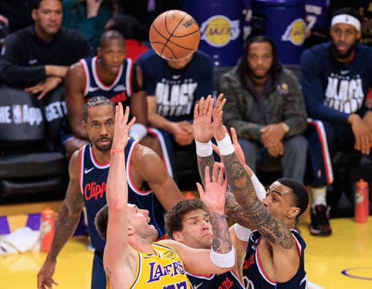 February 20, 2026, Los Angeles, California, USA: Luka Doncic 77 of the Los Angeles Lakers passes the ball over Brook Lopez 11 and John Collins 20 of the Los Angeles Clippers during a regular season NBA, Basketball Herren, USA game on Friday February 20, 2026 at Crypto.com Arena in Los Angeles, California. JAVIER ROJAS PI Los Angeles USA - ZUMAp124 20260220_zaa_p124_023 Copyright: xJavierxRojasx
