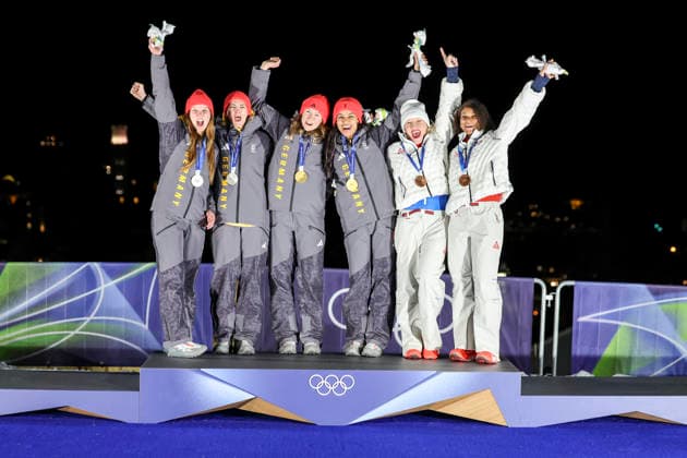 OLYMPICS - Winter Olympic Games, Olympische Spiele, Olympia, OS Milano Cortina 2026 CORTINA D AMPEZZO,ITALY,21.FEB.26 - OLYMPICS, BOBSLEIGH - Winter Olympic Games Milano Cortina 2026, 2-woman, heat 3 and 4, medal ceremony. Image shows the rejoicing of the rejoicing of Lisa Buckwitz, Neele Schuten, Levi Deborah, Laura Nolte (GER), Kaillie Armbruster Humphries and Jasmine Jones (USA). Keywords: medal.  GEPAxpictures xMaticxKlansek