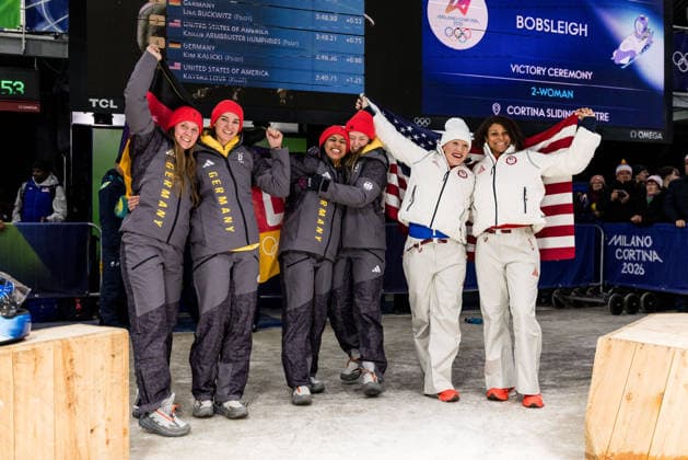 CORTINA, ITALY - FEBRUARY 21: The podium Silver medalists Lisa Buckwitz Neele Schuten (Germany), Gold medalists Laura Nolte Deborah Levi (Germany), Bronze medalists Kaillie Humphries Jasmine Jones (United States of America) cheer with flags during the Bobsleigh 2-woman Heat 3 and 4 at the Milano Cortina 2026 Olympics at Cortina Sliding Centre on day 15 of the Milano Cortina 2026 Olympics on February 21, 2026 in Cortina, Italy. Editorial use only. Italy Copyright: xSteffiexWunderlx