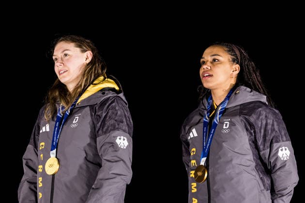 CORTINA, ITALY - FEBRUARY 21: Gold medalists Laura Nolte Deborah Levi (Germany) during the anthem during the Bobsleigh 2-woman medal ceremony at the Milano Cortina 2026 Olympics at Cortina Sliding Centre on day 15 of the Milano Cortina 2026 Olympics on February 21, 2026 in Cortina, Italy. Editorial use only. Italy Copyright: xSteffiexWunderlx