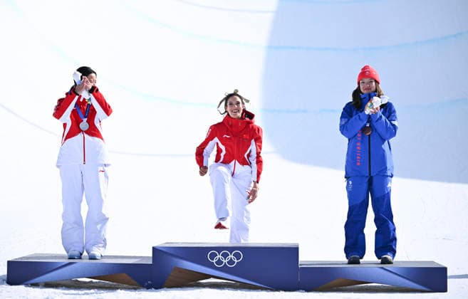 (260222) -- LIVIGNO, Feb. 22, 2026 -- Gold medalist Gu Ailing (C) of China steps onto the podium during the awarding ceremony for freestyle skiing women s freeski halfpipe at the Milan-Cortina 2026 Olympic Winter games, Winterspiele,Spiele, Summer games in Livigno, Italy, Feb. 22, 2026. ) (MICO2026)ITALY-LIVIGNO-OLYMPIC WINTER GAMES-FREESTYLE SKIING-WOMEN S FREESKI HALFPIPE-FINAL ZhangxHongxiang 