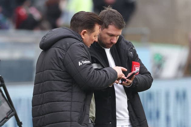 2 Bundesliga Hannover 96 Dynamo Dresden on 22 02 2026 at Heinz von Heiden Arena in Hannover Coach Christian Titz Hannover and press spokesman Christoph Heckmann Hannover watch scenes on a smartphone directly after the final whistle MH
