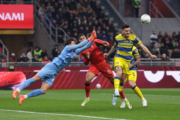 Milan, Italy, 22nd February 2026. Edoardo Corvi of Parma Calcio clahses with Ruben Loftus-Cheek of AC Milan as Emanuele Valeri of Parma Calcio heads the ball clear during the AC Milan vs Parma Serie A match at Giuseppe Meazza, Milan. Picture credit should read: Jonathan Moscrop Sportimage EDITORIAL USE ONLY. No use with unauthorised audio, video, data, fixture lists, club league logos or live services. Online in-match use limited to 120 images, no video emulation. No use in betting, games or single club league player publications. SPI_002_MILAN_PARMA SPI-4549-0002