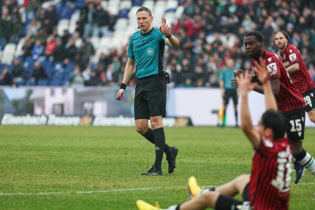 2 Bundesliga Hannover 96 Dynamo Dresden on 22 02 2026 at Heinz von Heiden Arena in Hannover Referee Martin Petersen gestures , player Daisuke Yokota Hannover sits in the foreground on the pitch MH