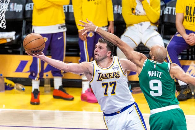 February 22, 2026, Los Angeles, California, United States: Los Angeles Lakers™ Luka Don?i? (77) goes past Boston Celtics™ Derrick White (9) to the basket during an NBA, Basketball Herren, USA basketball game at Crypto.com Arena on Sunday, Feb. 22, 2026 in Los Angeles. Los Angeles United States - ZUMAs197 20260222_aaa_s197_314 Copyright: xRingoxChiux