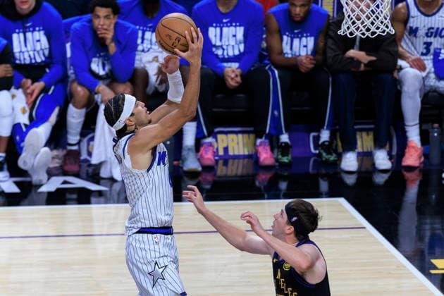 February 24, 2026, Los Angeles, California, USA: Anthony Black 0 of the Orlando Magic attempts a layup as Austin Reaves 15 of the Los Angeles Lakers defends the basket during their regular season NBA, Basketball Herren, USA game on Tuesday February 24, 2026 at Crypto.com Arena in Los Angeles, California. Lakers lose to Magic, 109-110. ARIANA RUIZ PI Lakers Vs. Magic  - ZUMAp124 20260224_zaa_p124_027 Copyright: xArianaxRuizx