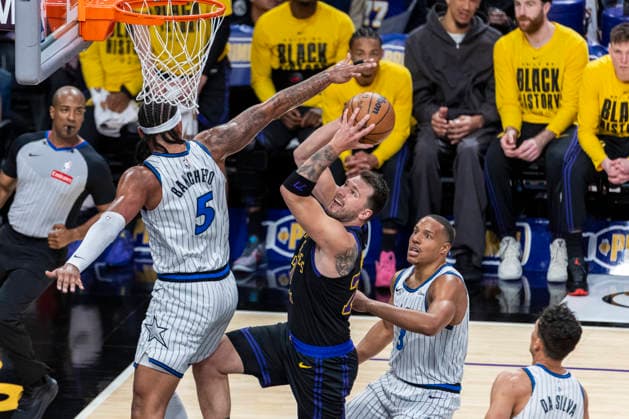 February 24, 2026, Los Angeles, California, United States: Los Angeles Lakers™ Luka Don?i? (77) goes to the basket under pressure from Orlando Magic™s Paolo Banchero (5) during an NBA, Basketball Herren, USA basketball game at Crypto.com Arena in Los Angeles. NBA 2026: Magic 110:109 Lakers. NBA 2026: Magic Vs Lakers In Los Angeles, US - 24 Feb 2026  - ZUMAs197 20260224_aaa_s197_327 Copyright: xRingoxChiux
