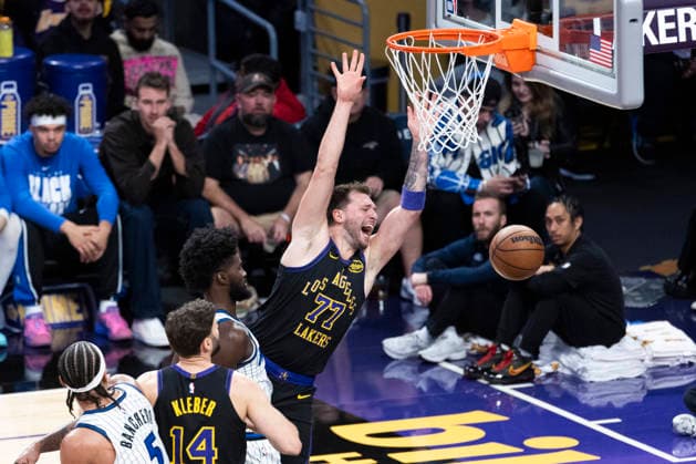 February 24, 2026, Los Angeles, California, United States: Los Angeles Lakers™ Luka Don?i? (77) goes to the basket under pressure from Orlando Magic™s Jonathan Isaac (1) during an NBA, Basketball Herren, USA basketball game at Crypto.com Arena in Los Angeles. NBA 2026: Magic 110:109 Lakers. NBA 2026: Magic Vs Lakers In Los Angeles, US - 24 Feb 2026  - ZUMAs197 20260224_aaa_s197_328 Copyright: xRingoxChiux