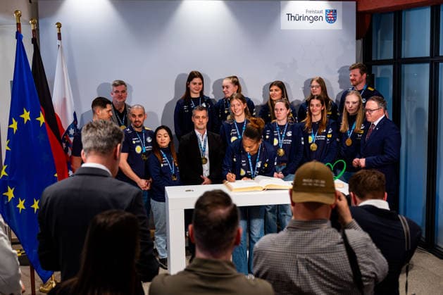 02 03 2026, GER, Volleyball, Women, Season 25 26, ZOI DVV Cup, Reception of the VfB 91 Suhl Lotto Thueringen team by the Thuringian Minister Mario Voigt VfB 91 Suhl Lotto Thueringen sensationally won the Zoi DVV German Volleyball Association Cup against Allianz MTV Stuttgart on 28 02 2026 in Mannheim On this occasion, the Thuringian State Chancellery around Mario Voigt, Stefan Gruhner, David Moeller and the Lord Mayor of Erfurt In the picture Sanaa Dotson VfB 91 Suhl Lotto Thueringen at the entry in the Golden Book of the city 99084 Erfurt Thuringian State Chancellery Thuringia Germany