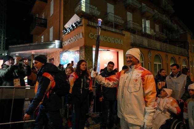 (260304) -- CORTINA D AMPEZZO, March 4, 2026 -- A torchbearer carrys the torch during the Milan-Cortina 2026 Paralympic Winter games, Winterspiele,Spiele, Summer games Torch Relay and Flame Unifying Ceremony in Cortina D Ampezzo, Italy, March 3, 2026. ) (SP)ITALY-CORTINA D AMPEZZO-PARALYMPIC WINTER GAMES-FLAME UNIFYING CEREMONY LianxZhen 