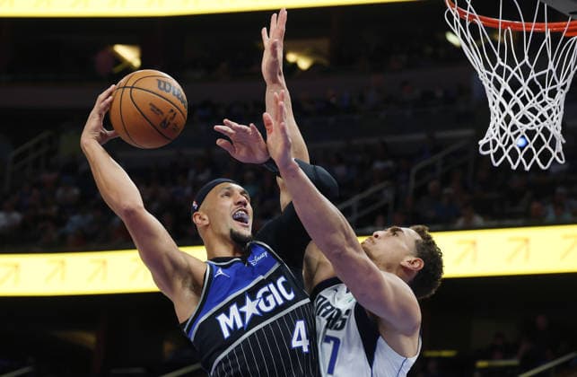 March 5, 2026, Orlando, Fl - Florida, USA: Orlando Magic guard Jalen Suggs (4) tries to shoot past Dallas Mavericks center Dwight Powell (7) during the NBA, Basketball Herren, USA game at the Kia Center on Thursday, March 5, 2026, in Orlando, Florida. Orlando USA - ZUMAm67_ 20260305_zaf_m67_012 Copyright: xStephenxM.xDowellx