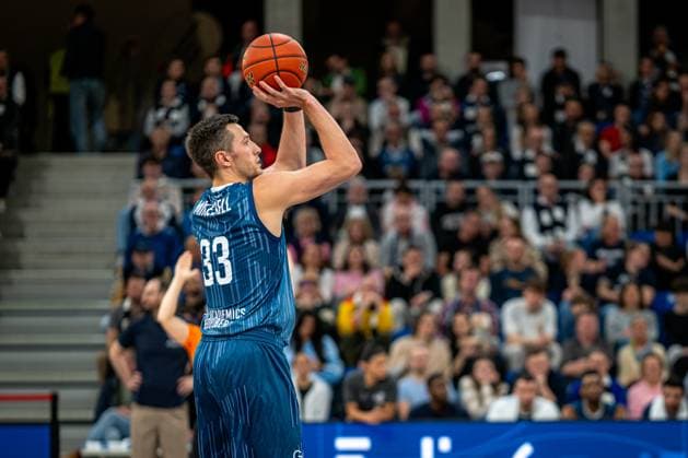 Game action with Ryan Mikesell 33 MLP Academics Heidelberg in blue jersey throwing easyCredit BBL MLP Academics Heidelberg - Alba Berlin 06 03 2026 Copyright: xspeedshotx
