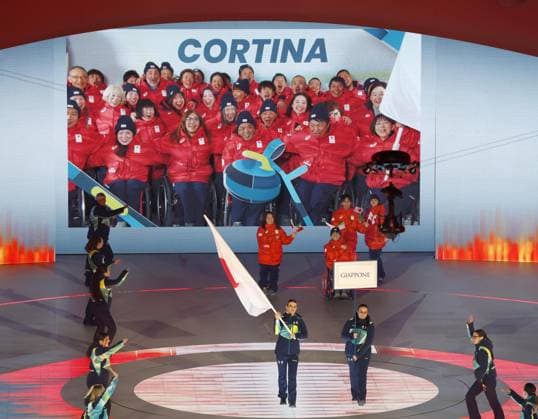 Milan Cortina Paralympics: Opening ceremony Japan s delegation, represented by para Ice hockey, Eishockey players Shunsuke Nakamura and Akari Fukunishi, marches during the opening ceremony of the Milan Cortina Paralympics at the Verona Arena, a Roman amphitheater in Verona, Italy, on March 6, 2026, while other members of the team are shown taking part in a pre-recorded message on a large screen in the back.  A14AA0005355679P