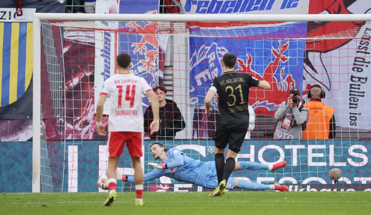Keven Schlotterbeck shoots penalty kick against goalkeeper Maarten Vandevoordt parries duel Game scene Action Sport Soccer Football DFL Bundesliga Men 25 Matchday Season 2025 2026 07 03 2026 RasenBallsport RB Leipzig RBL vs FC Augsburg FCA at RedBull Arena DFL regulations prohibit any use of photographs as image sequences and or quasi video