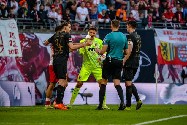 Finn Dahmen FC Augsburg, 01 complains to Martin Petersen referee, DFB about Christoph Baumgartner RB Leipzig, 14 , Arthur Chaves FC Augsburg, 34 , Keven Schlotterbeck FC Augsburg, 31 , RB Leipzig vs FC Augsburg, football, 1 Bundesliga, 25 Matchday, Season 2025 2026, 07 03 2026,¨ DFL REGULATIONS PROHIBIT ANY USE OF PHOTOGRAPHS AS IMAGE SEQUENCES AND OR QUASI VIDEO,¨ RB Leipzig vs FC Augsburg, Football, 1 Bundesliga, 25 Matchday, Season 2025 2026, 07 03 2026 Leipzig Copyright: xEibner-Pressefoto LauraxRoemerx EP_LRR