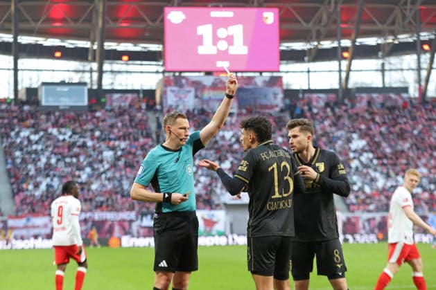 1 Soccer Bundesliga RB Leipzig FC Augsburg 07 03 2026 Referee Martin Petersen shows Dimitris Giannoulis 13, FC Augsburg the yellow card, warning In the background the video wall with the score of 1 1 draw LEIPZIG, GERMANY MARCH 7 Bundesliga match RB Leipzig FC Augsburg at Red Bull Arena on matchday 25 of Bundesliga 1 on March 7, 2026 in Leipzig, Germany DFL REGULATES PROHIBIT ANY USE OF PHOTOGRAPHS AS IMAGE SEQUENCES AND OR QUASI VIDEO Copyright: xBEAUTIFULxSPORTS JanxKaeferx