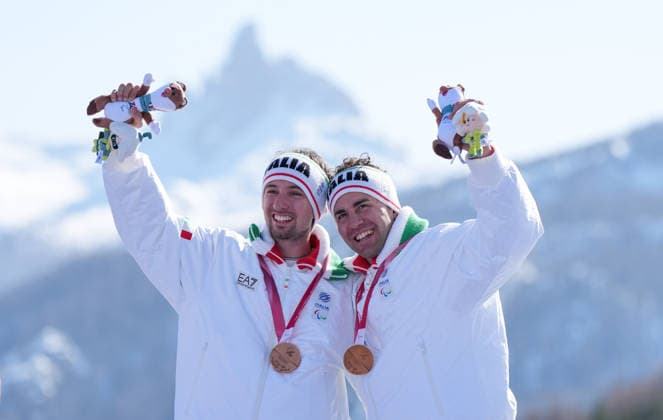 (260308) -- CORTINA D AMPEZZO, March 8, 2026 -- Bronze medalist Giacomo Bertagnolli (L) of Italy celebrates with his guide Andrea Ravelli during the awarding ceremony for the para alpine skiing men s downhill vision impaired match at the Milan-Cortina 2026 Paralympic Winter games, Winterspiele,Spiele, Summer games in Cortina D ampezzo, Italy, March 7, 2026. ) (SP)ITALY-CORTINA D AMPEZZO-PARALYMPIC WINTER GAMES-PARA ALPINE SKIING-MEN S DOWNHILL-VISION IMPAIRED WangxKaiyan 