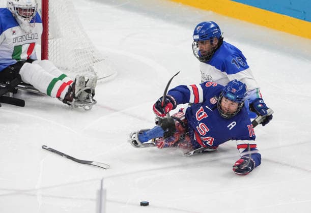 (260308) -- MILAN, March 8, 2026 -- Declan Farmer (front) of the United States battles for the puck with Nikko Landeros (back R) of Italy during the Para Ice hockey, Eishockey Preliminary Round Group A match between the United States and Italy at the Milan-Cortina 2026 Paralympic Winter games, Winterspiele,Spiele, Summer games in Milan, Italy, March 7, 2026. ) (SP)ITALY-MILAN-PARALYMPIC WINTER GAMES-PARA ICE HOCKEY-USA VS ITA HouxJun 