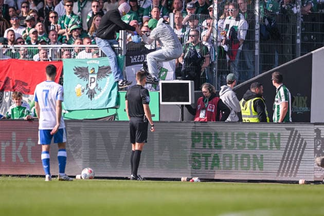 08 03 2026, Soccer, 2 Bundesliga, 25 Matchday Season 2025 2026, Preußen Münster Hertha BSC, Two masked men jump over the railing as referee Felix Bickel wants to look at the scene, xRHR PHOTO TKx Copyright: RHR-FOTOx RHR-FOTO TK