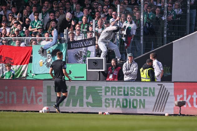 08 03 2026, Soccer, 2 Bundesliga, 25 Matchday Season 2025 2026, Preußen Münster Hertha BSC, Two masked men jump over the railing as referee Felix Bickel wants to look at the scene, xRHR PHOTO TKx Copyright: RHR-FOTOx RHR-FOTO TK