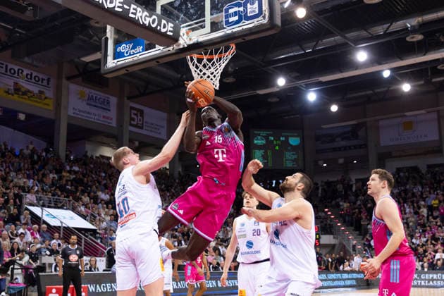Kur JONGKUCH BON 15, mi on the ball in a duel against Collin WELP MBC 40, left and Djurisic NEMANJA MBC 42, right , under the basket, action final score 88 72, Basketball 1 Bundesliga Telekom Baskets Bonn SYNTAINICS MBC BON vs MBC Main Round 23 Matchday, in T E L E C O M D O M E, on 08 03 2026, Â